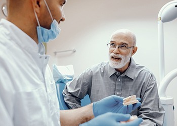 senior man asking his implant dentist in Cumberland questions about dental implants 