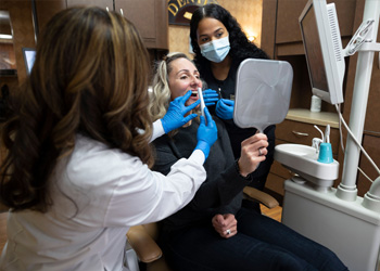 Woman in dental chair giving thumbs up