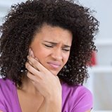 Woman holding cheek in pain