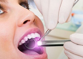 Woman receiving oral cancer screening