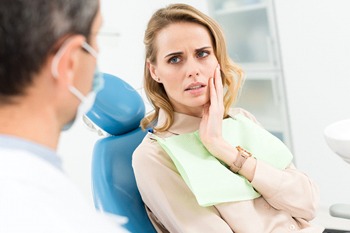 woman with toothache talking to dentist