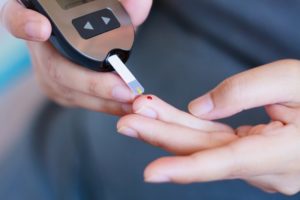 a person checking their blood sugar before visiting their dentist in Cumberland