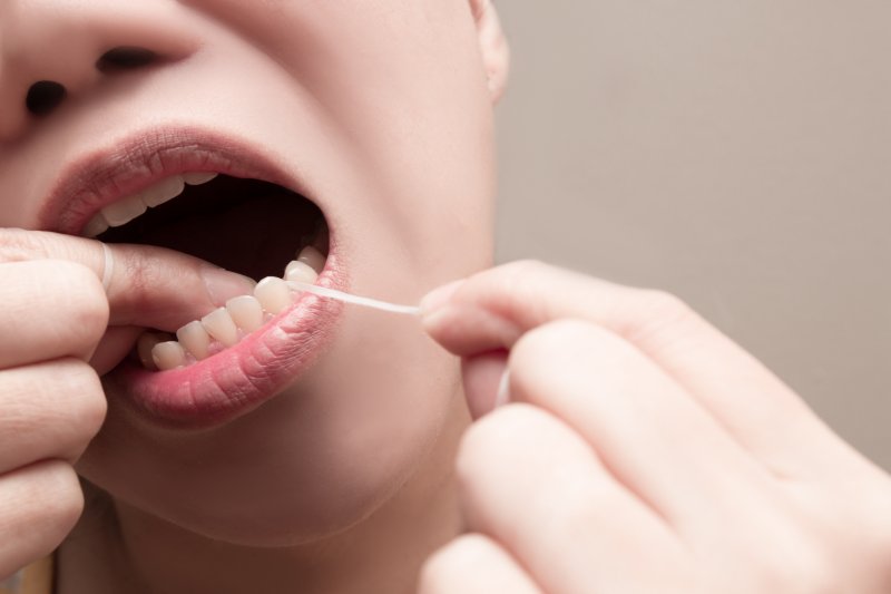 Woman flossing between teeth to prevent cavities