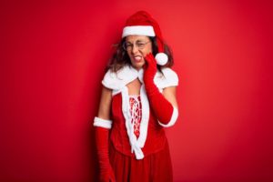 woman in a holiday outfit with a toothache 
