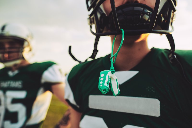 Green Mouthguard Hanging from a Child’s Helmet