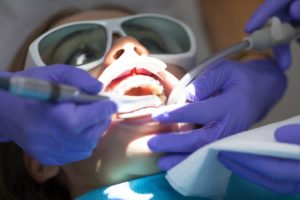 a woman receiving a soft tissue laser treatment at the dentist