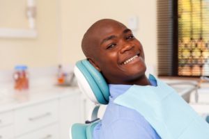 a man smiling at a dental checkup and ready to ask his dentist questions